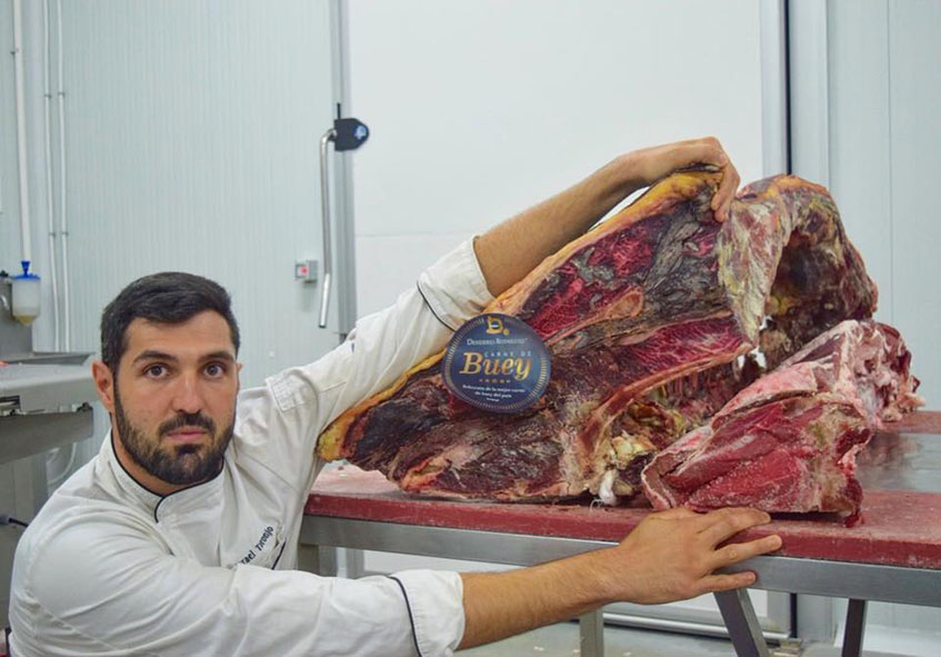 Israel Toronjo con un costillar de buey, una carne que sirven por encargo ya que los chuletones tienen más de 4 kilos. Foto: Cedida por el establecimiento. 